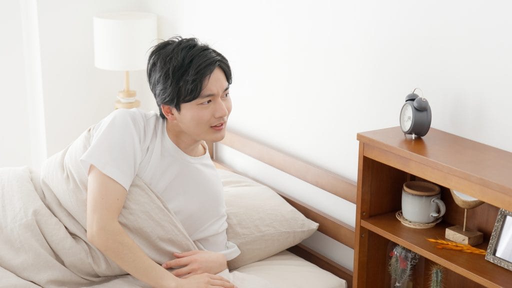 A man checking the time on his alarm clock
