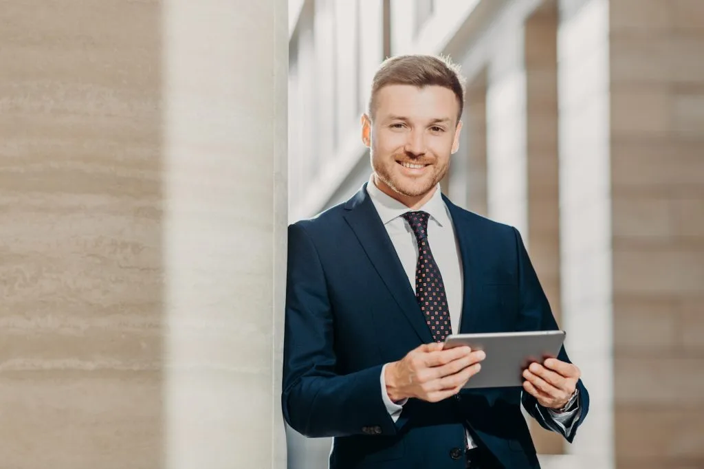 Businessman checks email or updates profile on digital tablet computer